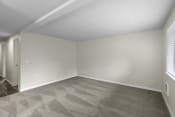 Thumbnail 15 of 30 - a bedroom with tan walls and a gray carpet at Swiss Gables Apartment Homes, WA 98032
