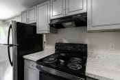 Thumbnail 28 of 30 - a kitchen with white cabinets and black appliances at Swiss Gables Apartment Homes, Kent, 98032