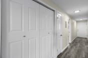 Thumbnail 30 of 30 - a long hallway with white closet doors and white walls at Swiss Gables Apartment Homes, Kent, WA