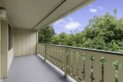 Thumbnail 9 of 30 - a large balcony with a view of the treeline at Swiss Gables Apartment Homes, WA 98032