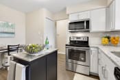 Thumbnail 7 of 31 - a kitchen with white cabinetry and stainless steel appliances