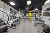 Thumbnail 45 of 62 - a gym with weights and cardio equipment on the floor and a wall mounted tv