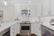 Thumbnail 17 of 62 - a white kitchen with stainless steel appliances and white cabinets