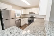 Thumbnail 15 of 22 - a kitchen with granite counter tops and stainless steel appliances