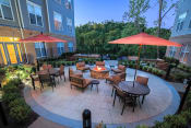 Thumbnail 6 of 21 - a patio with tables and umbrellas and a fire pit