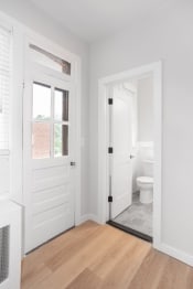 Thumbnail 11 of 23 - a white bathroom with a white door and a white toilet