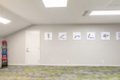 Thumbnail 13 of 27 - an empty room with a white door and paintings on the wall
