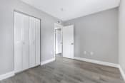 Thumbnail 8 of 35 - an empty room with white closet doors and a door to a hallway