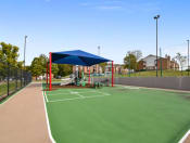 Thumbnail 26 of 27 - a basketball court with a playground and a blue canopy