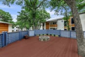 Thumbnail 14 of 17 - a large deck with a firepit and a blue fence