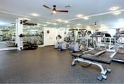 Thumbnail 4 of 17 - a gym with cardio equipment and a ceiling fan