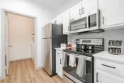 Thumbnail 19 of 43 - a kitchen with white cabinets and stainless steel appliances and a refrigerator