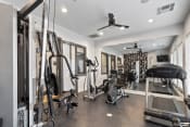 Thumbnail 21 of 28 - a gym with weights and cardio equipment in a home for sale