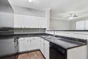 Thumbnail 7 of 28 - a kitchen with white cabinets and granite counter tops and a sink