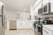 Thumbnail 5 of 43 - a renovated kitchen with white cabinets and stainless steel appliances