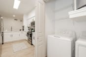 Thumbnail 41 of 43 - a laundry room with a washer and dryer and a kitchen with white appliances