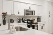 Thumbnail 1 of 43 - a modern kitchen with white cabinets and a sink