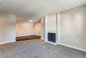 Thumbnail 5 of 19 - an empty living room with a fireplace and a carpeted floor