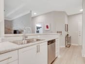 Thumbnail 10 of 17 - a large kitchen with white cabinets and a stainless steel sink