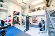 Thumbnail 26 of 26 - a gym with weights and cardio machines and a staircase
