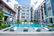 Thumbnail 4 of 26 - a swimming pool in front of an apartment building