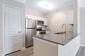 Thumbnail 1 of 26 - a kitchen with a large island and stainless steel appliances