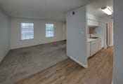 Thumbnail 7 of 19 - an empty living room and kitchen with wood flooring and white cabinets