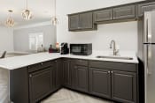 Thumbnail 28 of 30 - a kitchen with gray cabinets and white countertops