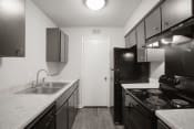Thumbnail 8 of 30 - a kitchen with black appliances and white countertops