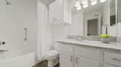 Thumbnail 43 of 44 - a bathroom with white cabinets and a white bathtub