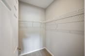 Thumbnail 12 of 41 - an empty closet with white walls and a white door
