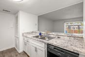 Thumbnail 3 of 29 - a kitchen with white cabinets and granite counter tops and a sink
