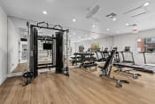 Thumbnail 17 of 24 - a gym with treadmills and other exercise equipment on a wooden floor
