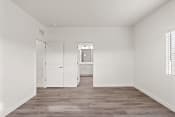 Thumbnail 9 of 24 - an empty bedroom with white walls and wood flooring