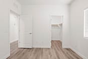 Thumbnail 13 of 24 - an empty bedroom with white walls and wood flooring