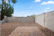 Thumbnail 18 of 24 - a backyard with a retaining wall and gravel