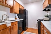 Thumbnail 7 of 44 - a kitchen with wooden cabinets and a black refrigerator