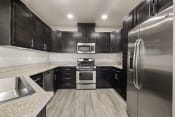 Thumbnail 1 of 26 - a kitchen with stainless steel appliances and black cabinets