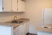 Thumbnail 2 of 7 - Des Moines Apartments - Marina Club - Kitchen Area with White Cabinetry, White Appliances, and Granite-Style Countertops