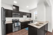 Thumbnail 3 of 32 - a kitchen with dark wood cabinetry and stainless steel appliances