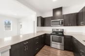 Thumbnail 1 of 32 - a kitchen with dark cabinets and white countertops