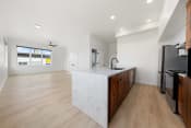 Thumbnail 6 of 81 - a large kitchen with a marble counter top and wooden cabinets