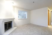 Thumbnail 5 of 7 - Des Moines Apartments for Rent - Marina Club - Living Room with Fireplace, Carpeting, and a Large Window