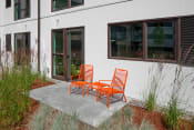 Thumbnail 19 of 45 - a pair of orange adirondack chairs sit on a concrete patio in front of a