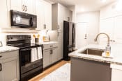 Thumbnail 32 of 40 - a kitchen with black appliances and granite counter tops