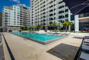 Thumbnail 3 of 19 - Miami FL Apartments - MB Station - Large Sparkling Pool Surrounded by Lounge Seating
