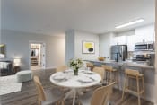 Thumbnail 3 of 45 - a dining area with a white table and chairs and a kitchen in the background