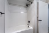 Thumbnail 32 of 45 - a bathroom with a white bathtub and a shower with a black shower head