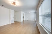 Thumbnail 4 of 19 - an empty living room with a large window and wood flooring