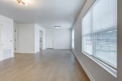 Thumbnail 5 of 19 - an empty living room with a large window and wood flooring